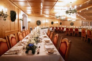 Lang gedeckter Tisch in einem stilvollen Speiseraum mit Kerzen und Blumenarrangements