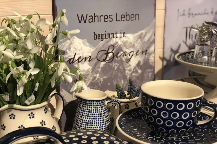 Tassen und Blumen in Berglandschaft